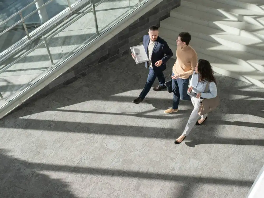 Above view of 3 co-workers walking through an office building